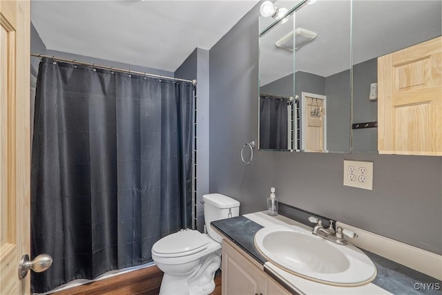 bathroom featuring toilet, wood finished floors, and vanity