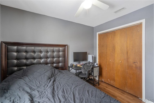 bedroom featuring ceiling fan, visible vents, and wood finished floors