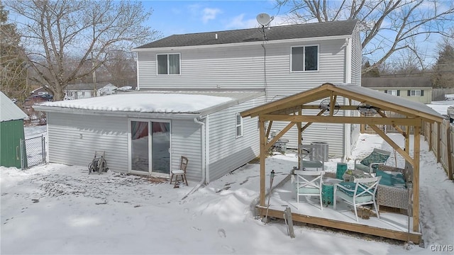 snow covered rear of property featuring a deck, a gazebo, central air condition unit, and fence