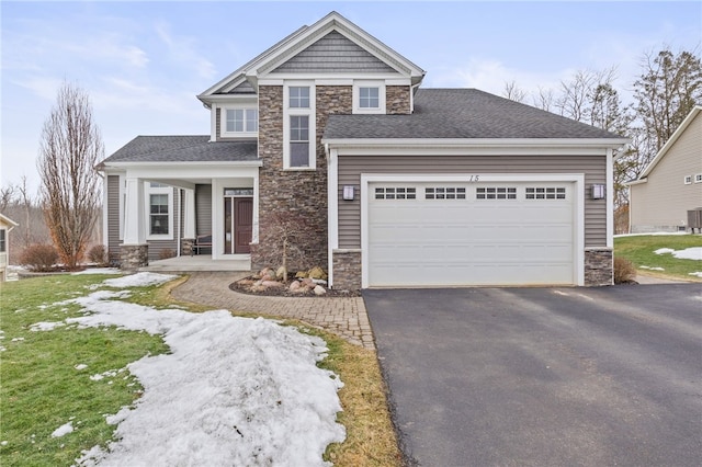 craftsman inspired home with stone siding, driveway, and an attached garage