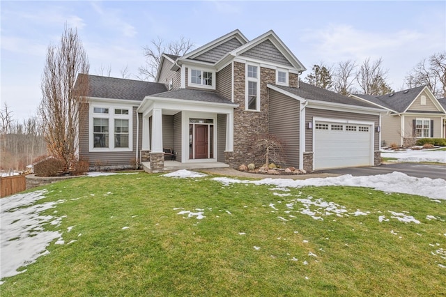 view of front facade featuring aphalt driveway, a garage, a lawn, and stone siding