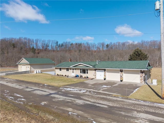 view of front of property featuring a front yard, an attached garage, and driveway