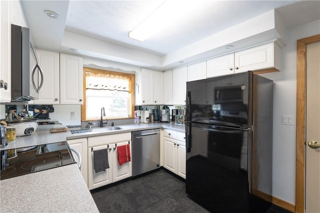 kitchen featuring a sink, stainless steel appliances, white cabinets, light countertops, and a raised ceiling