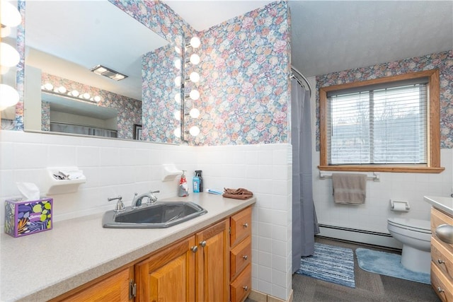 bathroom with a wainscoted wall, baseboard heating, tile walls, and wallpapered walls