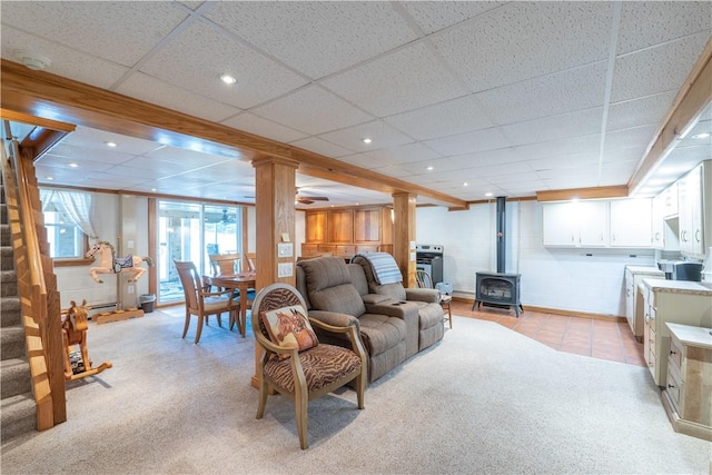 living area with stairs, light colored carpet, recessed lighting, and a wood stove