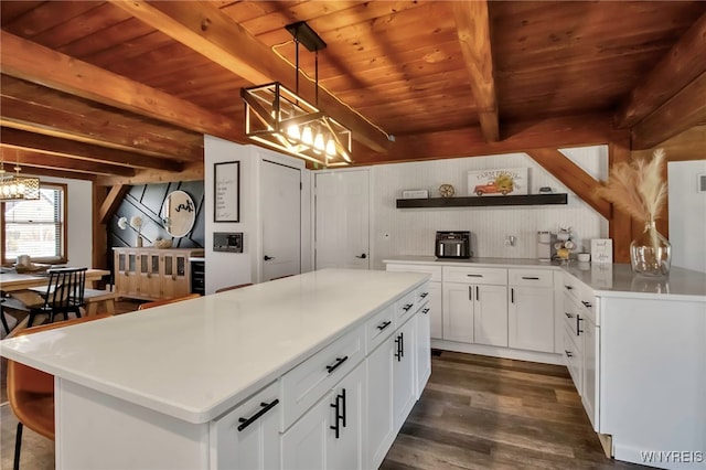 kitchen with beamed ceiling, wooden ceiling, white cabinetry, and dark wood-type flooring