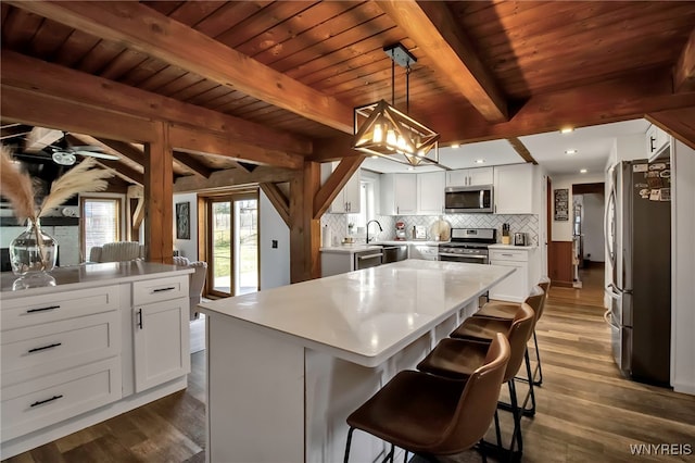 kitchen featuring tasteful backsplash, dark wood-style floors, appliances with stainless steel finishes, and white cabinetry