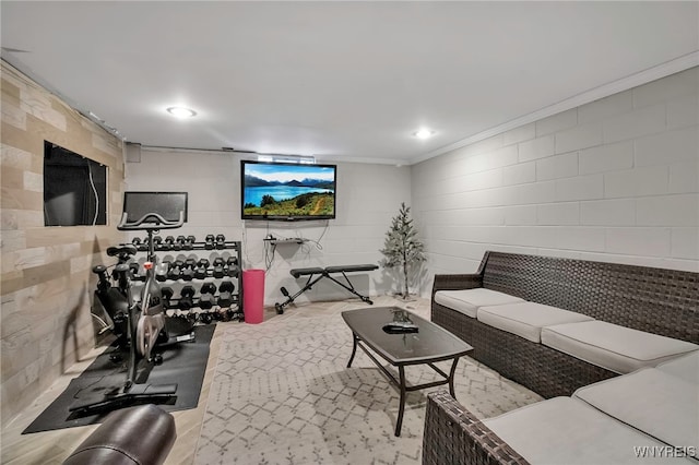 living area with recessed lighting, concrete block wall, and ornamental molding