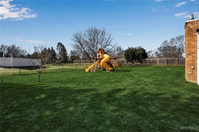 community play area with a lawn and a fenced backyard