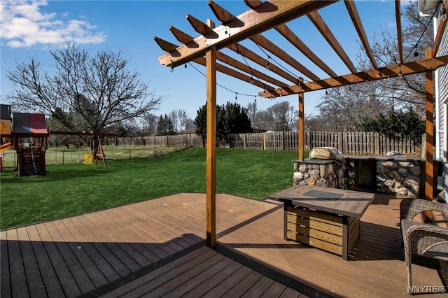 wooden deck featuring a yard, a fenced backyard, and a playground