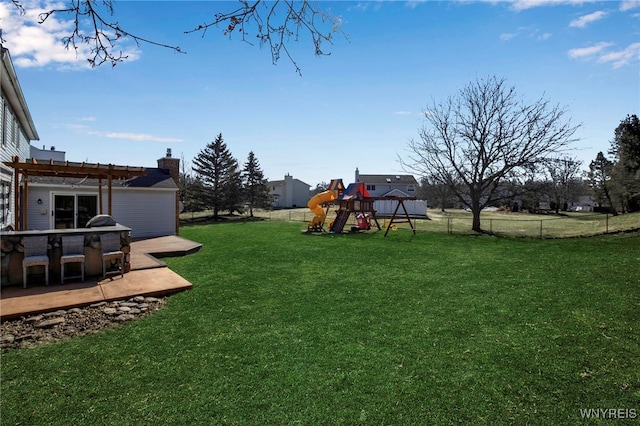 view of yard featuring a playground, fence, a pergola, and a wooden deck