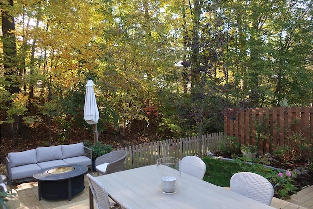 view of patio with an outdoor living space with a fire pit, outdoor dining space, and fence