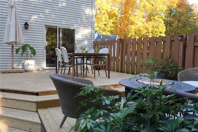 wooden deck with outdoor dining space and fence