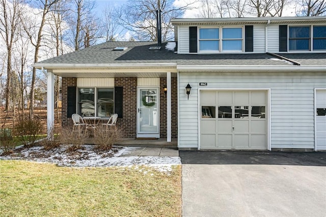 traditional-style house with a porch, brick siding, and driveway