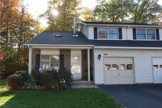 view of front of house with brick siding, driveway, a garage, and roof with shingles