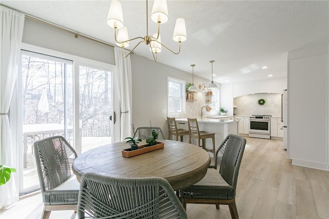 dining room featuring an inviting chandelier, recessed lighting, light wood-style floors, and a textured ceiling