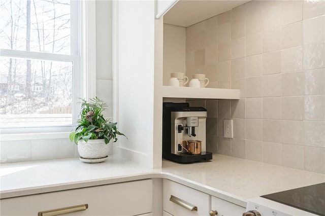 interior details featuring tasteful backsplash, light countertops, and white cabinetry