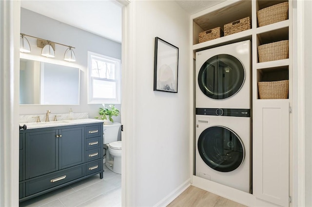 laundry room with a sink, laundry area, and stacked washing maching and dryer