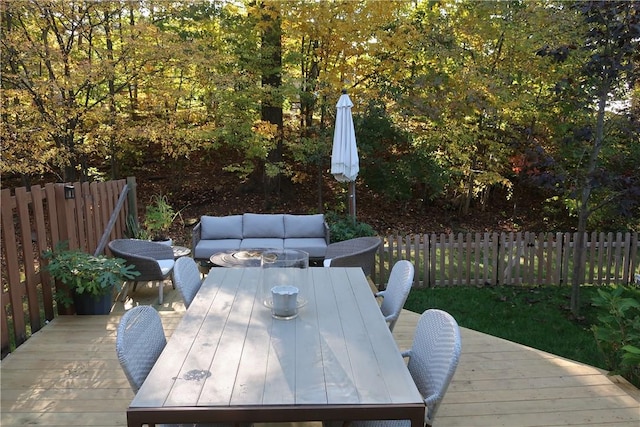 wooden terrace featuring an outdoor living space, outdoor dining area, and fence