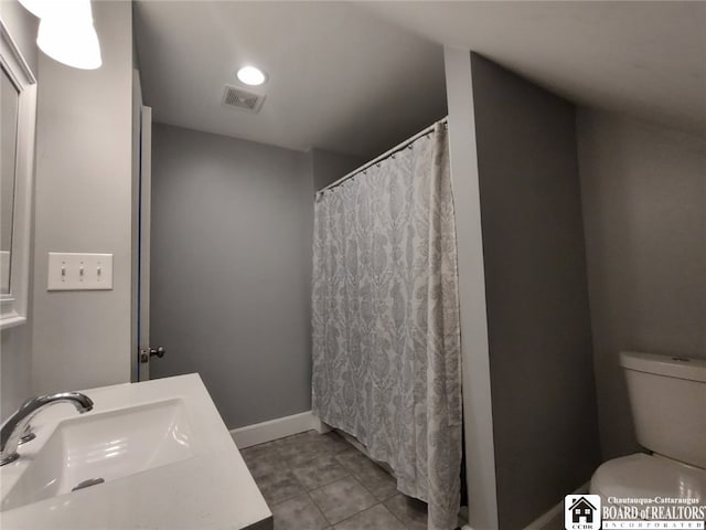 bathroom with visible vents, toilet, a sink, tile patterned flooring, and baseboards