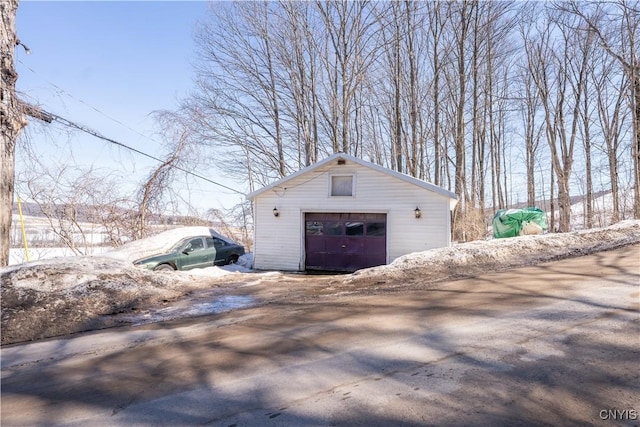 detached garage featuring dirt driveway