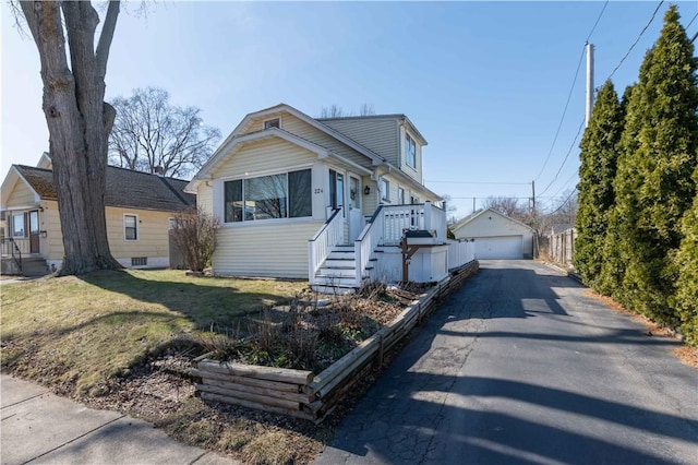 bungalow-style house with an outbuilding, a detached garage, and a front yard