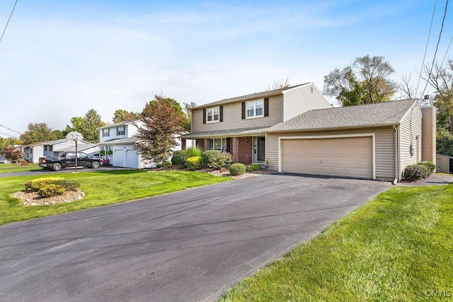 traditional-style home with driveway, a front lawn, a garage, brick siding, and a chimney