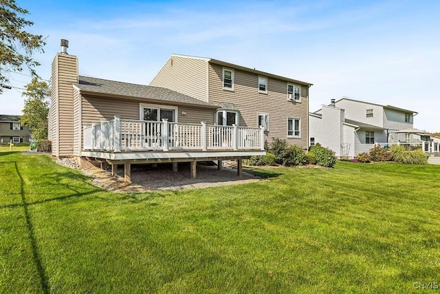 back of house featuring a yard, a deck, and a chimney