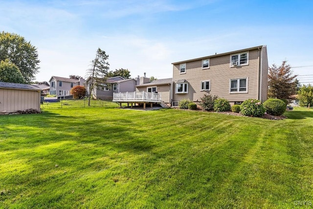 rear view of house featuring a yard and a deck