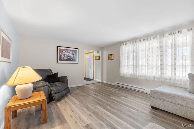 living area featuring baseboards, baseboard heating, and wood finished floors