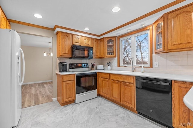 kitchen with a sink, black appliances, light countertops, glass insert cabinets, and brown cabinets