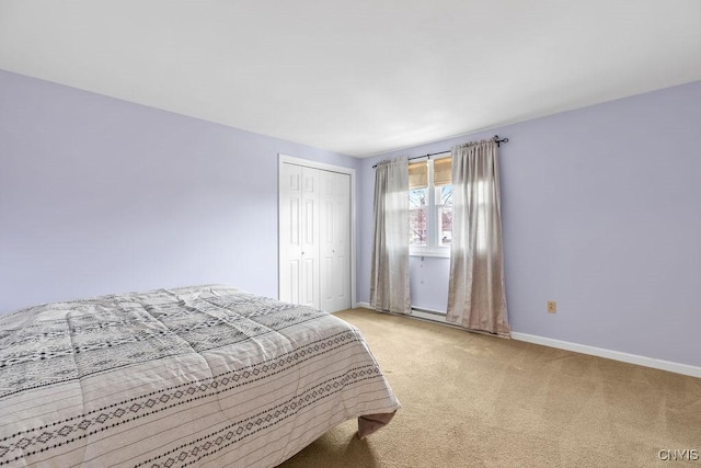 bedroom with light carpet, a closet, and baseboards