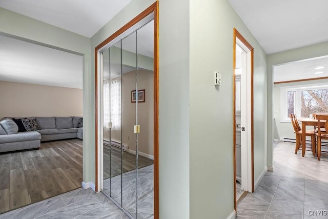 hallway with baseboards and a baseboard radiator