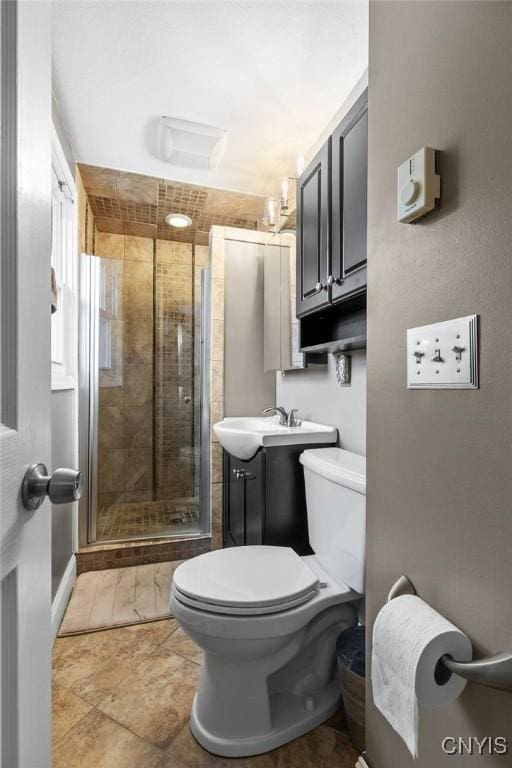 full bath with toilet, a stall shower, and vanity