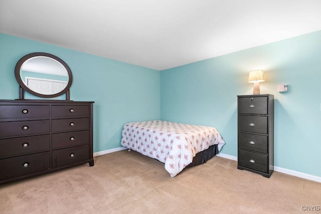 bedroom featuring light colored carpet and baseboards