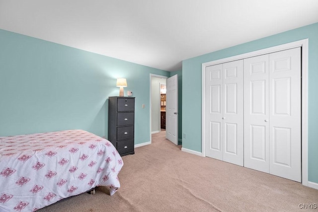 bedroom with carpet flooring, baseboards, and a closet