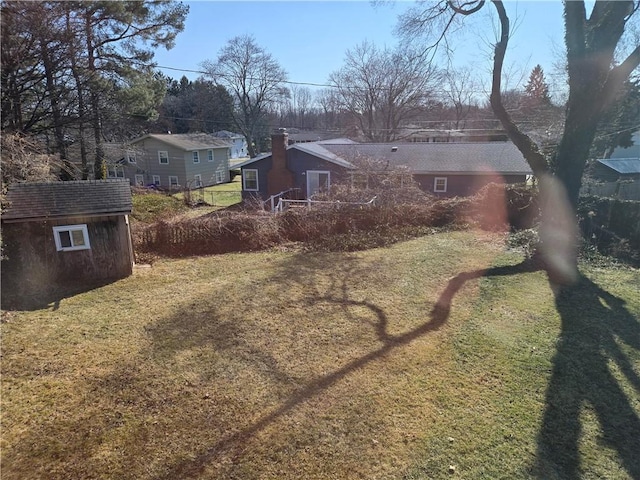 view of yard featuring an outbuilding, a shed, and driveway