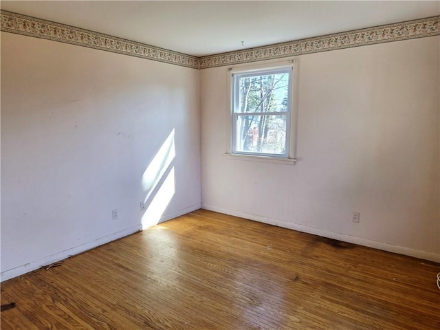 unfurnished room featuring baseboards and wood finished floors