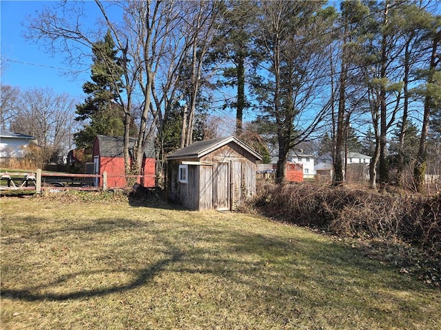 view of yard with an outbuilding, a shed, and fence