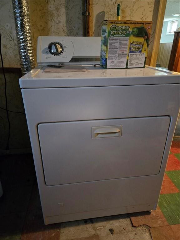 interior details featuring wallpapered walls and washer / dryer