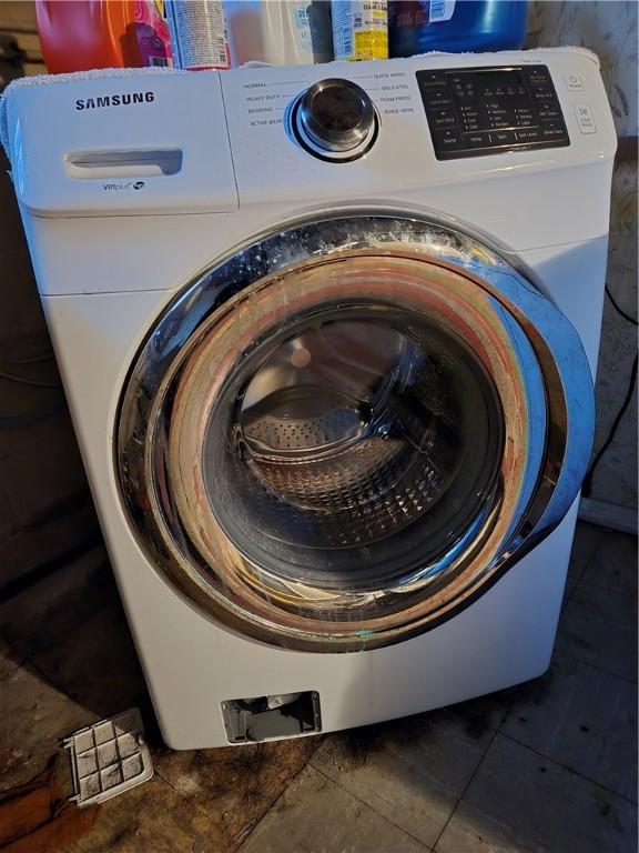 clothes washing area featuring tile patterned floors, washer / dryer, and laundry area