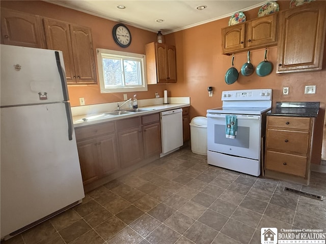 kitchen with white appliances, ornamental molding, brown cabinetry, and a sink