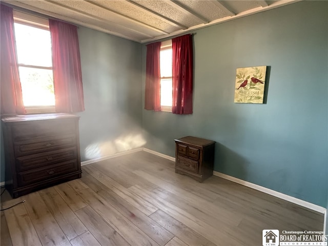 unfurnished bedroom with baseboards and wood finished floors