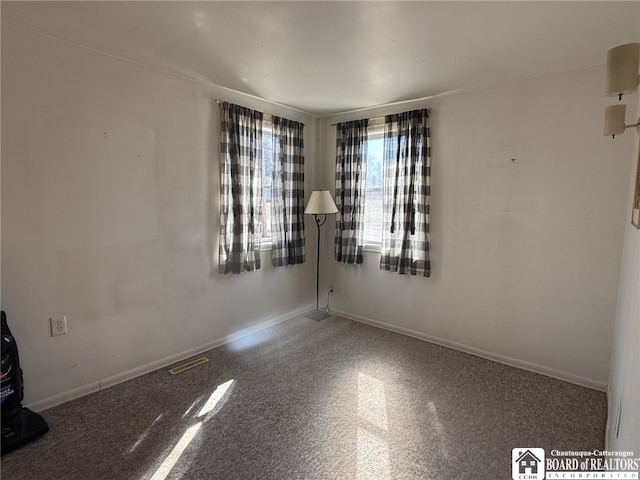 unfurnished room with visible vents and baseboards