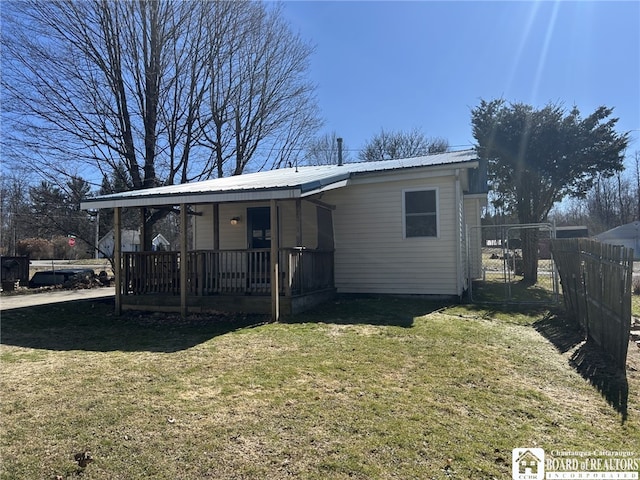 view of front of property with a front lawn, fence, and metal roof