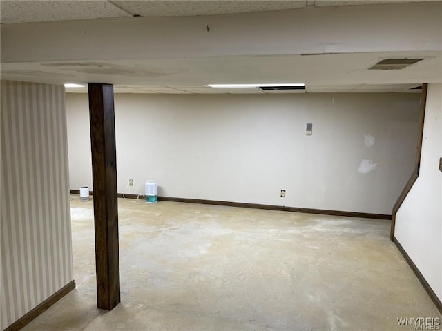 finished basement with visible vents, a paneled ceiling, and baseboards