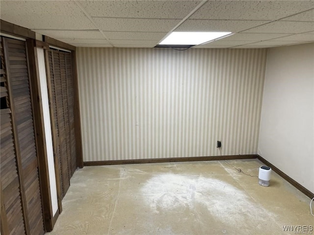 basement featuring baseboards and a drop ceiling