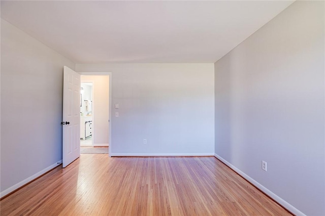 empty room featuring baseboards and light wood-style floors