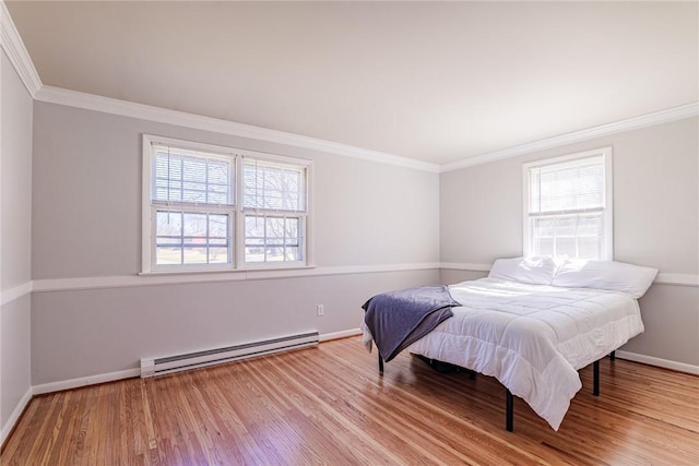 bedroom with ornamental molding, wood finished floors, baseboards, and a baseboard radiator