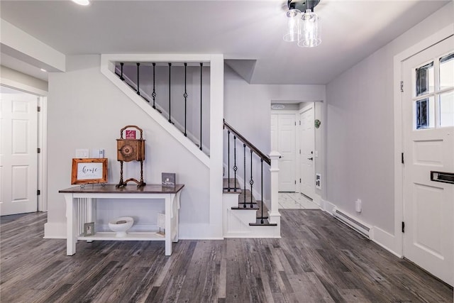 foyer with stairway, baseboards, wood finished floors, and a baseboard radiator